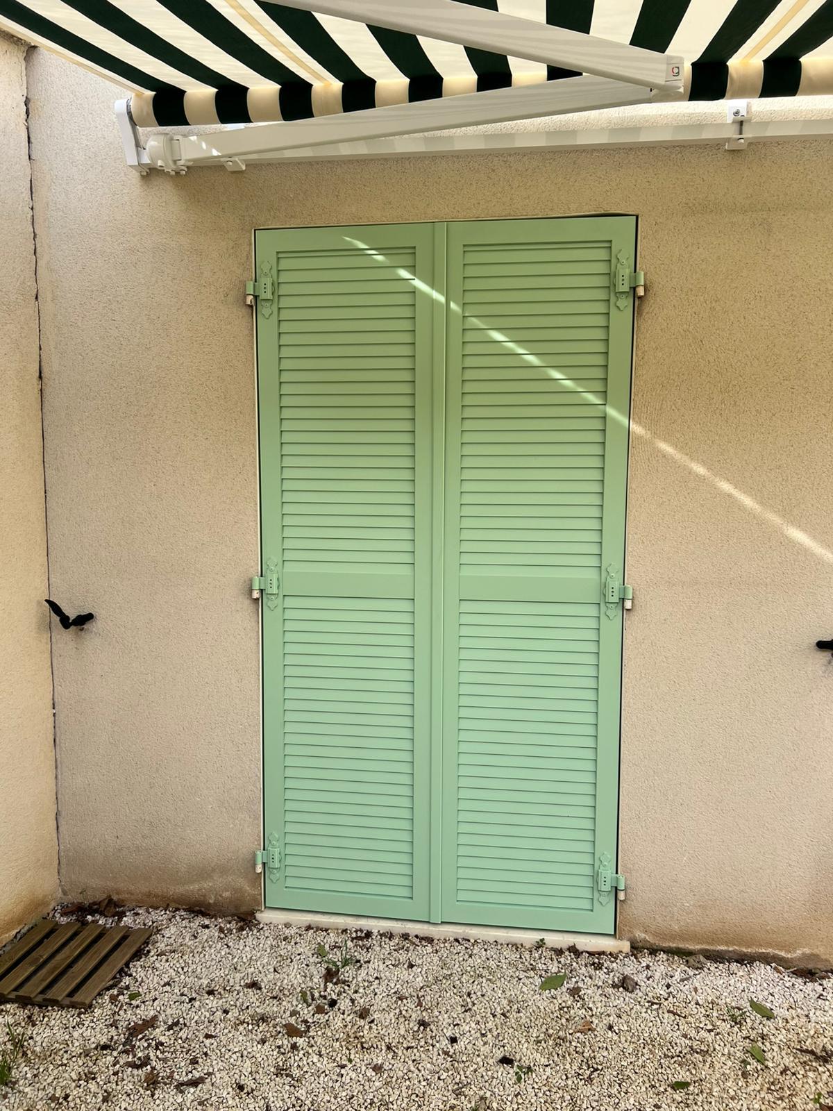 Volets battants aluminium persiennés sur porte fenêtre 2 vantaux fermés vert pastel à Bron